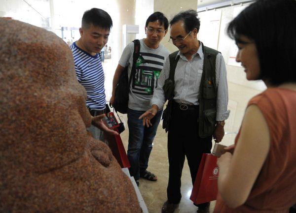 专门从福建来到现场的文艺家二期学员、书法家张宇(右二)与海外一期学员、雕塑家李纲(左一)在李纲作品《莫言》前交流